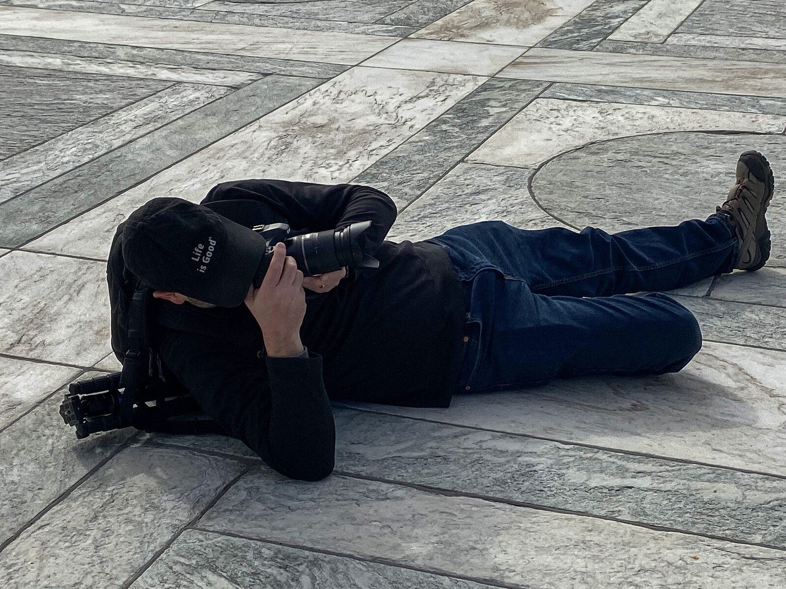 Brad Balfour lying down to photograph the Washington Monument from the base